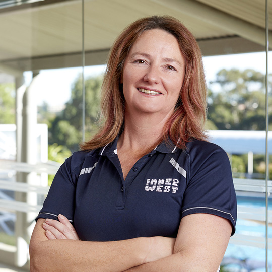 Personal trainer Avril smiling at the camera with arms crossed wearing a navy Inner West Council branded shirt